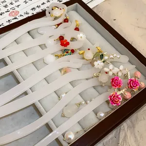 Elegant Chinese style hair sticks with floral and rabbit charms in a jewelry tray.