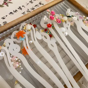 Close-up of white semi-translucent hair sticks with floral and leaf charms