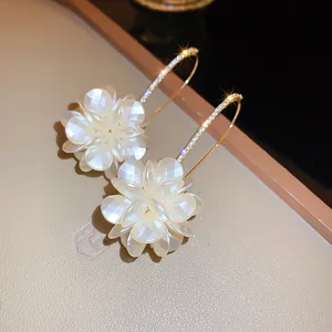 Eleganti orecchini in stile francese con petali di fiori bianchi e finitura dorata.
