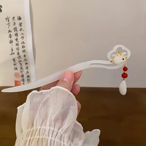 Close-up of elegant white Chinese hair stick with gold rabbit and red bead details