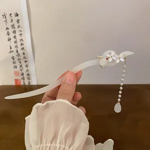 Close-up detail of an elegant translucent hair stick featuring a rabbit and pearl tassel