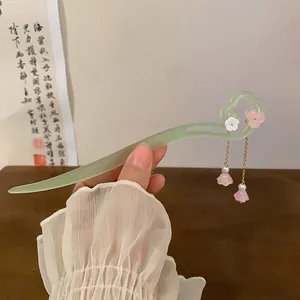 Close-up of an elegant light green Chinese style hairpin with pink floral charms