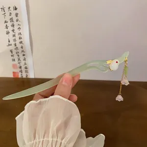 Detail shot of a jade-green Chinese style hair stick featuring a rabbit and floral tassel