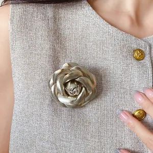 Exquisite close-up view of an elegant gold rose flower brooch pinned on a tweed garment