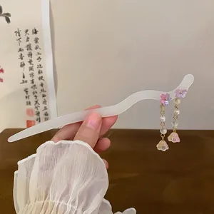 Close-up of a white wavy hair stick with delicate pink flower and pearl charms