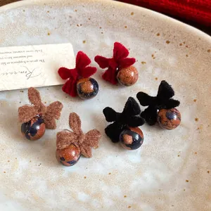 Orecchini a perno con fiocco floccato e perle glitterate in rosso, nero e marrone.