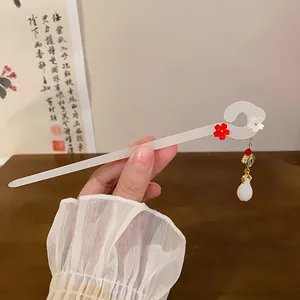 Detailed close-up of a New Chinese style white resin hairpin with a red flower detail