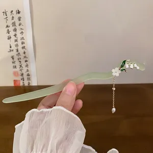 Elegant lily of the valley hair stick with green jade-like finish and pearl tassel detail.