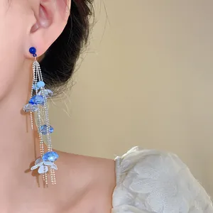 Elegantes pendientes largos de borlas de cuentas de vidrio azul con detalle de hoja