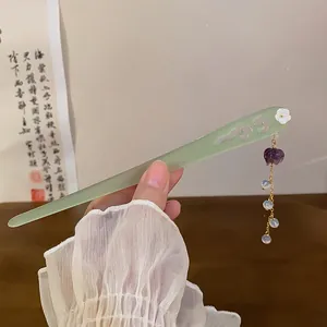 Detailed view of a light green Chinese hair stick with a purple flower tassel for Hanfu