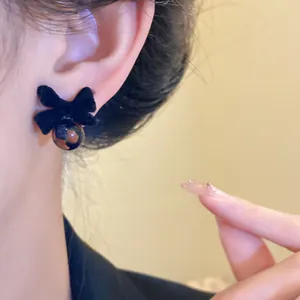 Vista dettagliata di un orecchino a fiocco in velluto nero con un design a perla a scacchi