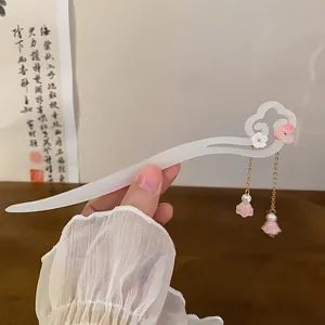 Close-up of elegant white hair stick with pink flower and pearl tassels