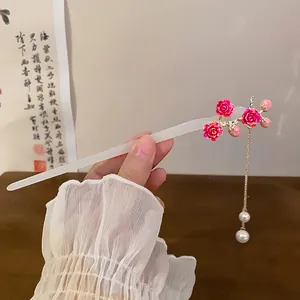 Close-up view of a new Chinese style rose hair stick with pearl tassel held by hand