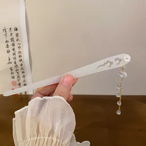 Close-up of white Chinese style hair stick with cloud pattern and tassel
