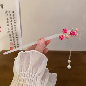 Close-up view of an elegant Chinese style hair stick featuring pink roses and pearl tassels.