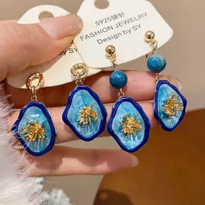 Detailed view of blue stone-like flower earrings on fashion jewelry display card