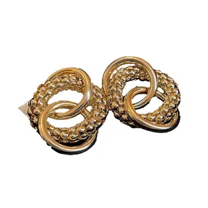 Elegant golden knotted circular stud earrings with minimalist metallic interlocking rings