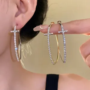 Elegant silver needle hoop earrings with rhinestone-encrusted cross design for a chic look