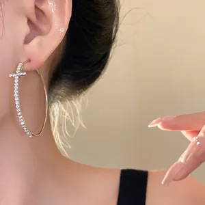 Detailed view of elegant silver hoop earring featuring a brilliant diamond cross design