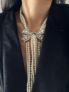 Detail of elegant French style pearl necklace with rhinestone bow and tassels