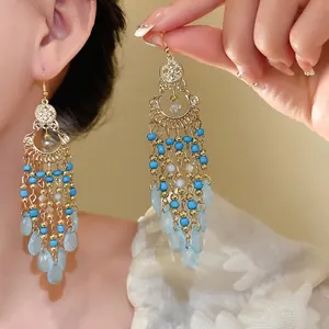 Bohemian style drop earrings featuring vibrant blue seed beads and clear acrylic waterdrop tassels.