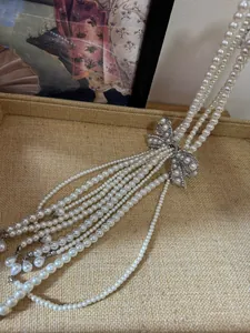 Detail of French style multi-strand pearl necklace with rhinestone bow charm