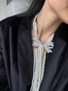 Elegant French multi-strand pearl necklace featuring a sparkling rhinestone bow detail.