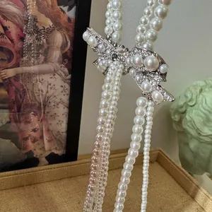 Close-up of elegant rhinestone bow pendant on multi-strand French style pearl necklace
