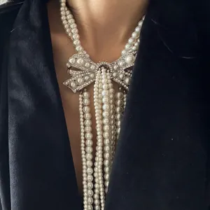 Detailed view of elegant multi-strand pearl necklace with rhinestone bow centerpiece