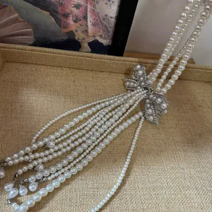 Close-up detail of elegant French pearl necklace featuring a rhinestone bow design