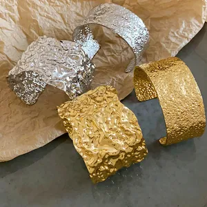 Detailed shot of gold and silver open cuff bracelets with unique crushed and hammered textures