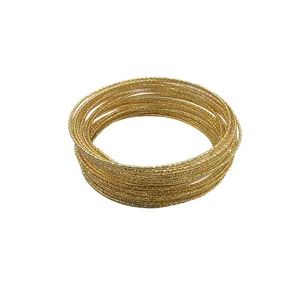 Elegante stapel gouden metalen armbanden met textuur en gegraveerde patronen voor dames