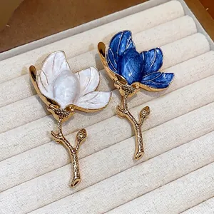 Elegant enamel flower brooches in white and blue, luxury fashion clothing accessories.