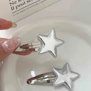 Close-up of two shiny silver metallic star-shaped snap hair clips for women and girls