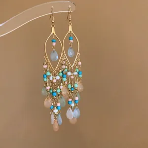 Detail view of Bohemian teardrop earrings featuring colorful seed beads and gold hooks.