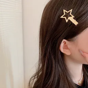 Elegant gold hollow star hair clip accessory shown worn on a female model's side