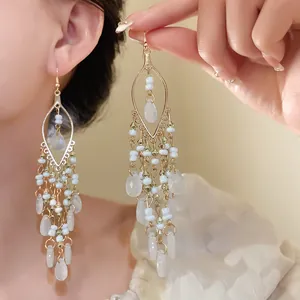 Detailed view of Bohemian chandelier earrings with white seed beads and teardrop charms
