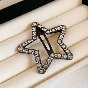 Detailed macro view of an elegant black star hair clip adorned with clear rhinestones