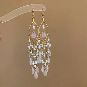 Detailed macro view of bohemian chandelier earrings with white seed beads and teardrops