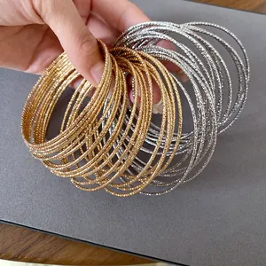 Gedetailleerd macrozicht op getextureerde gouden en zilveren metalen armbanden voor dames