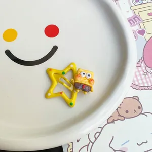 Macro view of a cute yellow star-shaped hair clip with a cartoon sponge character