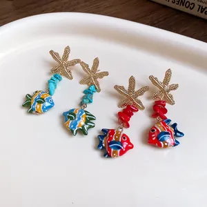 Detailed view of tropical starfish and colorful glass fish pendant earrings for vacation