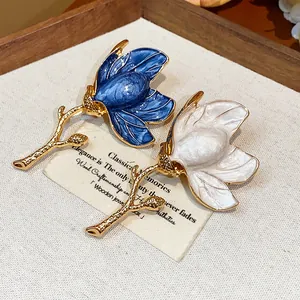 Detailed close-up view of elegant blue and white enamel flower brooches with golden stems