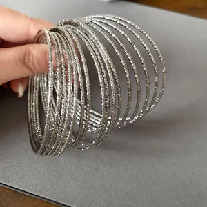 Detailopname van zilverkleurige metalen armbanden met complexe gegraveerde patronen