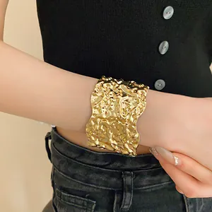 Close-up of a gold hammered metal cuff bracelet with a unique crinkled texture