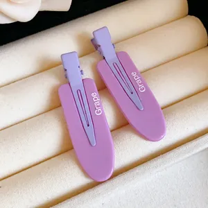 Detail of purple no-crease hair clips with Grape text on white display tray