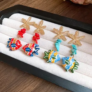 Detailed macro view of starfish drop earrings with colorful glass fish and stone beads