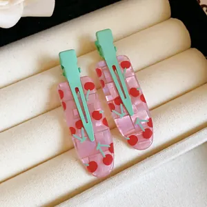 Close-up of pink cherry pattern acrylic duckbill hair clips on velvet tray