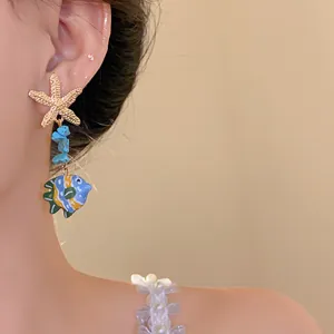 Detail shot of ocean themed starfish and colorful glass fish drop earrings for summer.