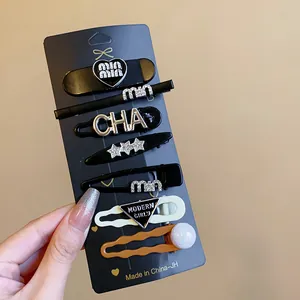 Close-up view of various black, white, and brown stylish hair clips on a display card.